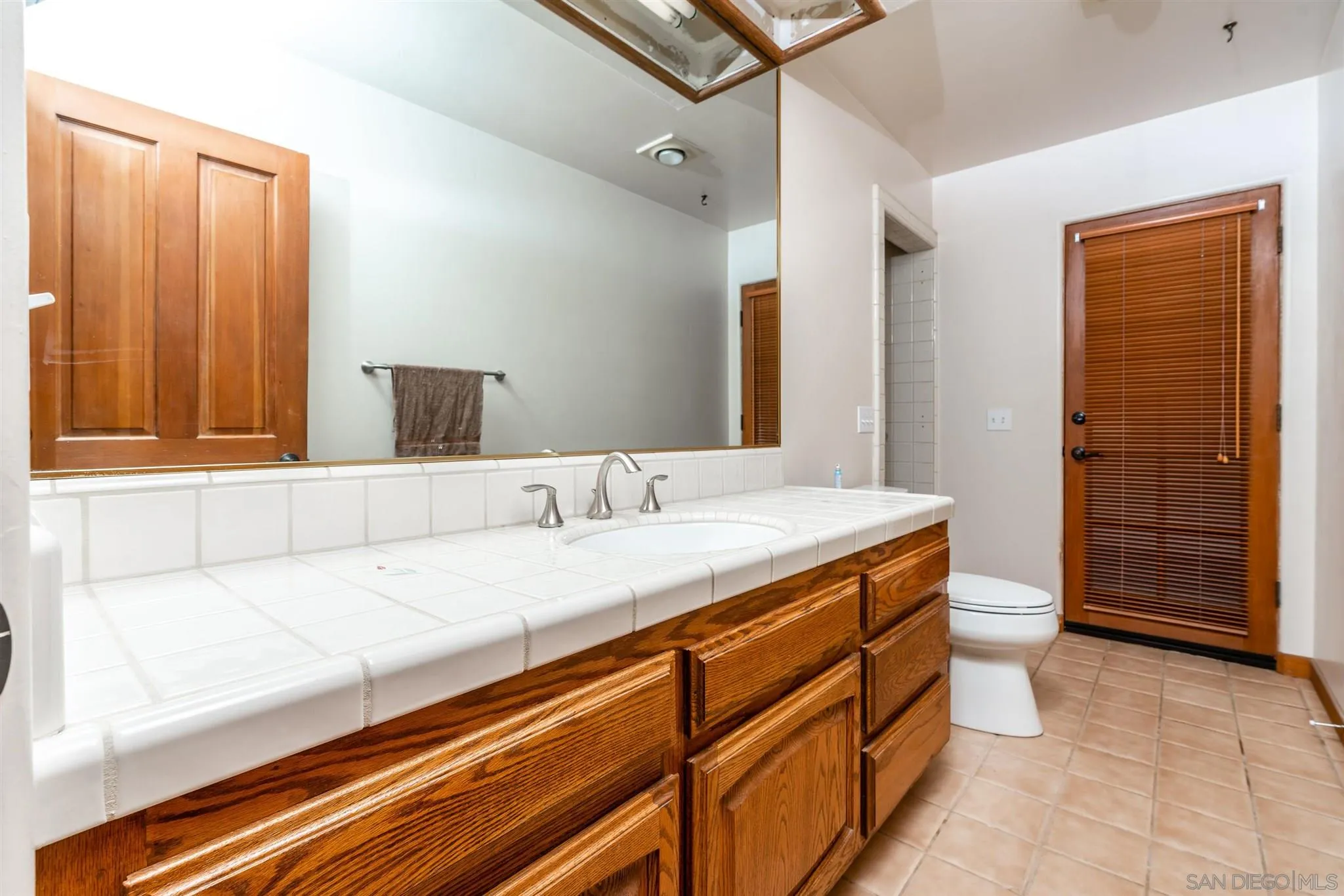 9340 Huntley Road Fallbrook, CA 92028 - Photo 32 of 49 a bathroom with a granite countertop sink a toilet and shower