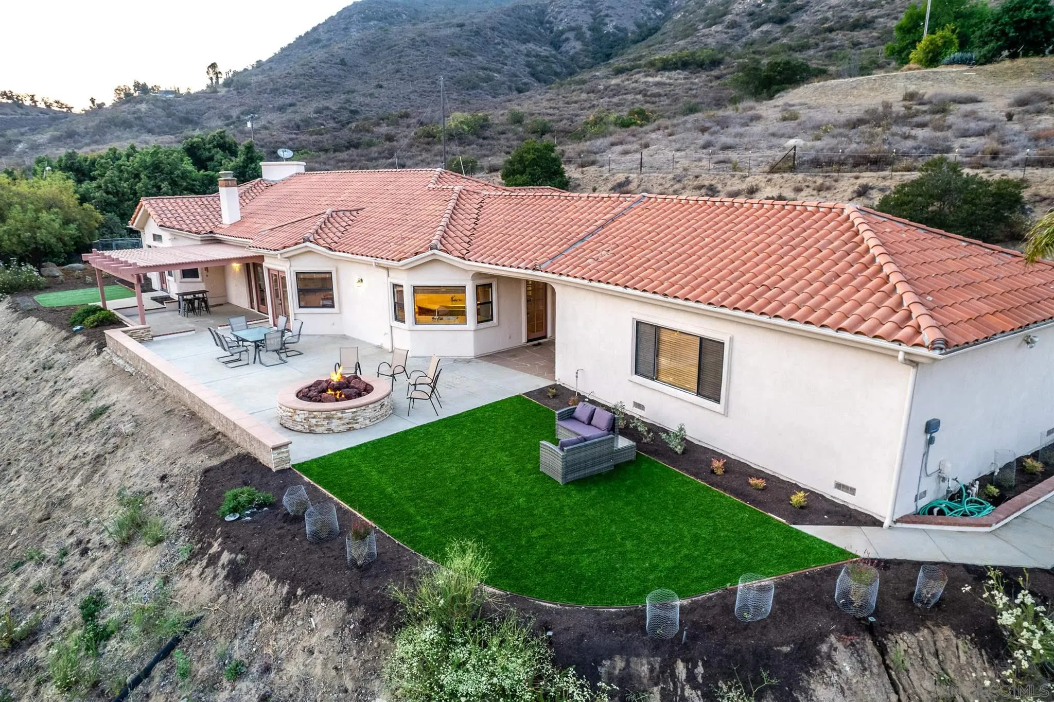 9340 Huntley Road Fallbrook, CA 92028 - Photo 6 of 49 a aerial view of a house with table and chairs under an umbrella