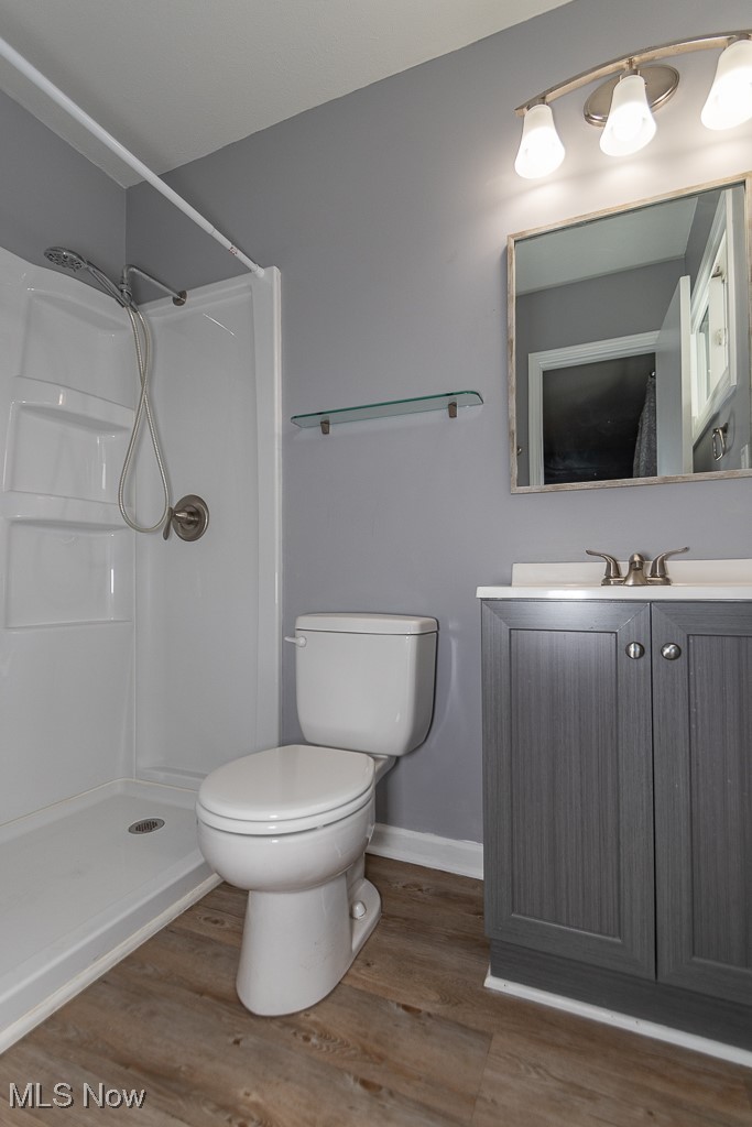 7996 Munson Road Mentor, OH 44060 - Photo 17 of 33 Bathroom featuring a shower, hardwood / wood-style floors, vanity, and toilet
