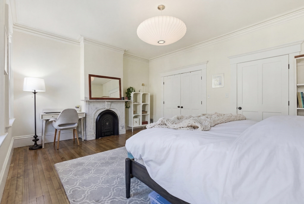 38 Bartlett Street Boston, MA 02129 - Photo 19 of 37 a spacious bedroom with a bed and a fireplace