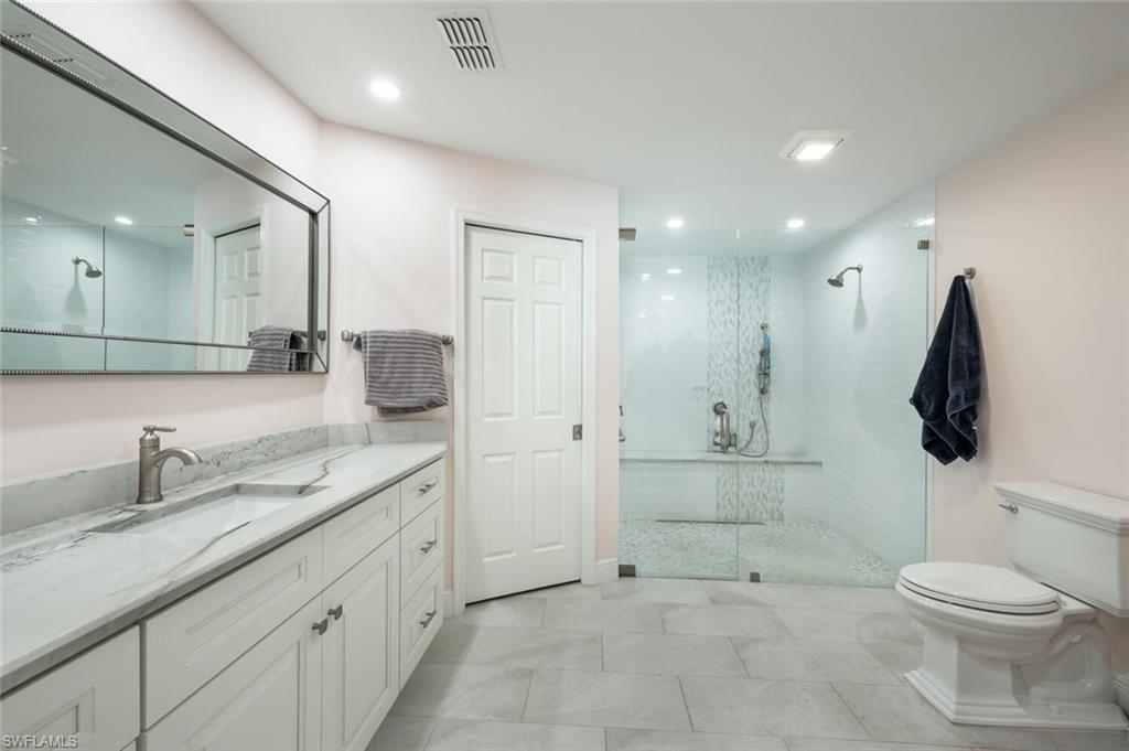 640 Augusta Boulevard Naples, FL 34113 - Photo 12 of 29 a bathroom with a granite countertop sink a toilet and a shower