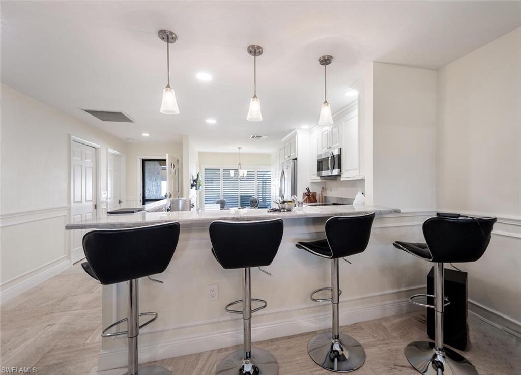 640 Augusta Boulevard Naples, FL 34113 - Photo 5 of 29 a view of kitchen and dining area with granite countertop wooden cabinets