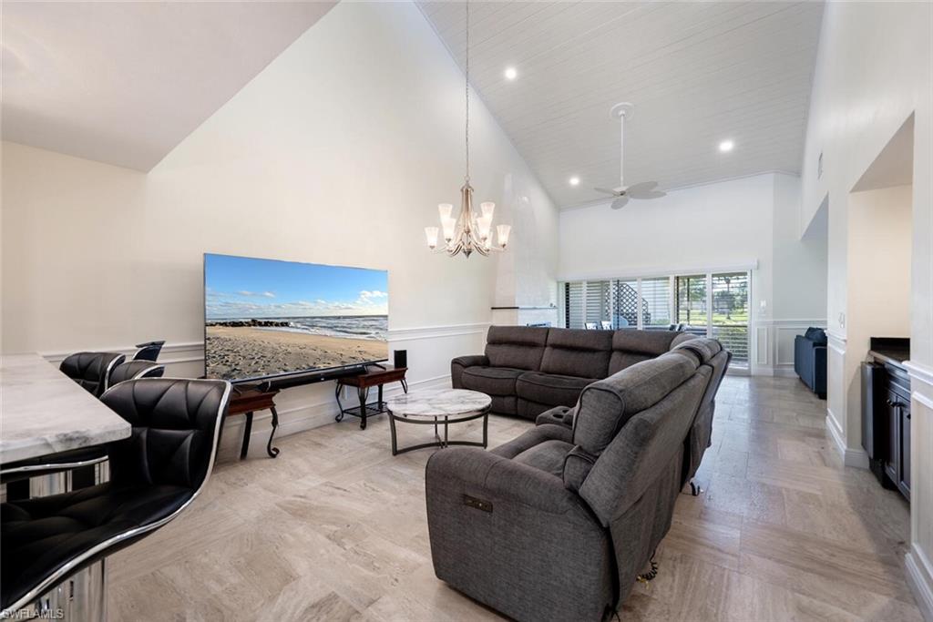 640 Augusta Boulevard Naples, FL 34113 - Photo 7 of 29 a living room with furniture a chandelier and a flat screen tv