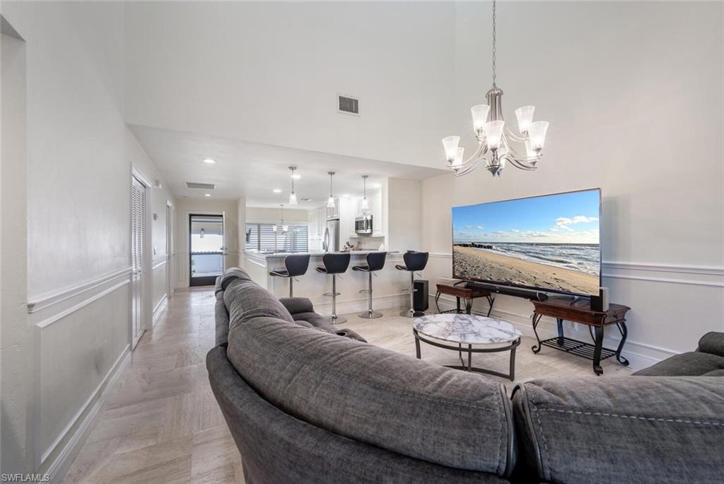 640 Augusta Boulevard Naples, FL 34113 - Photo 8 of 29 a living room with furniture a chandelier and kitchen view