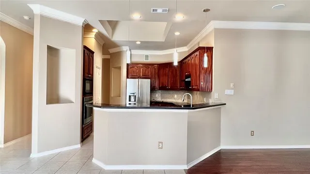 a kitchen with stainless steel appliances granite countertop a refrigerator a sink and a microwave