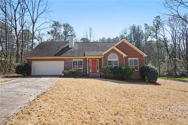 a front view of a house with a yard covered in snow
