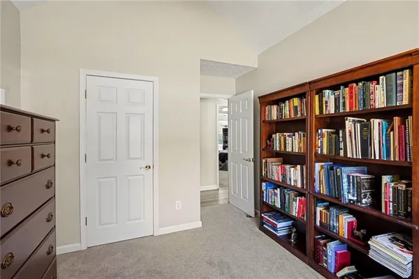 a view of room with windows book shelves