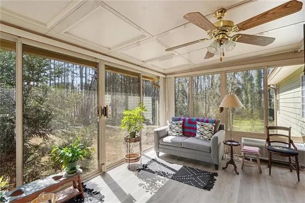 a living room with furniture and a large window with garden view