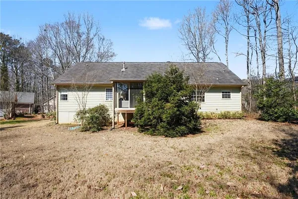 a view of a house with a large tree and a yard