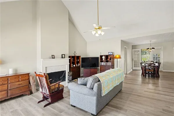 a living room with furniture and a dining table with wooden floor