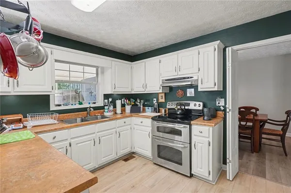a kitchen with stainless steel appliances granite countertop a stove a sink and a microwave