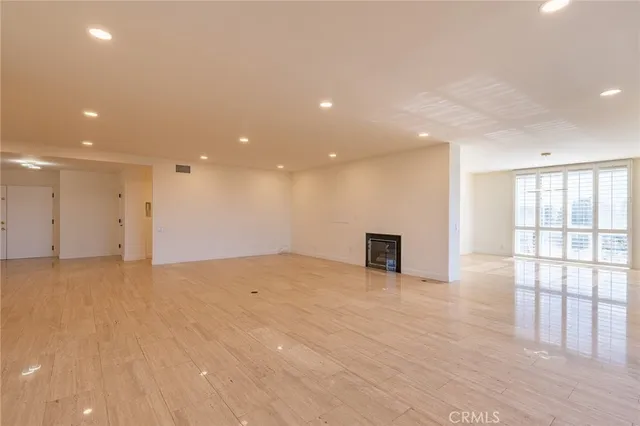 a view of empty room with wooden floor and fireplace