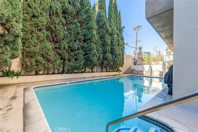 a view of a small house with a small pool and sitting area