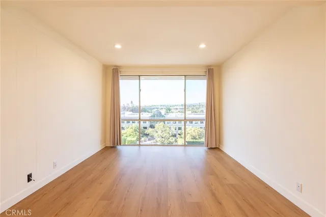 a view of a room with wooden floor and has more windows