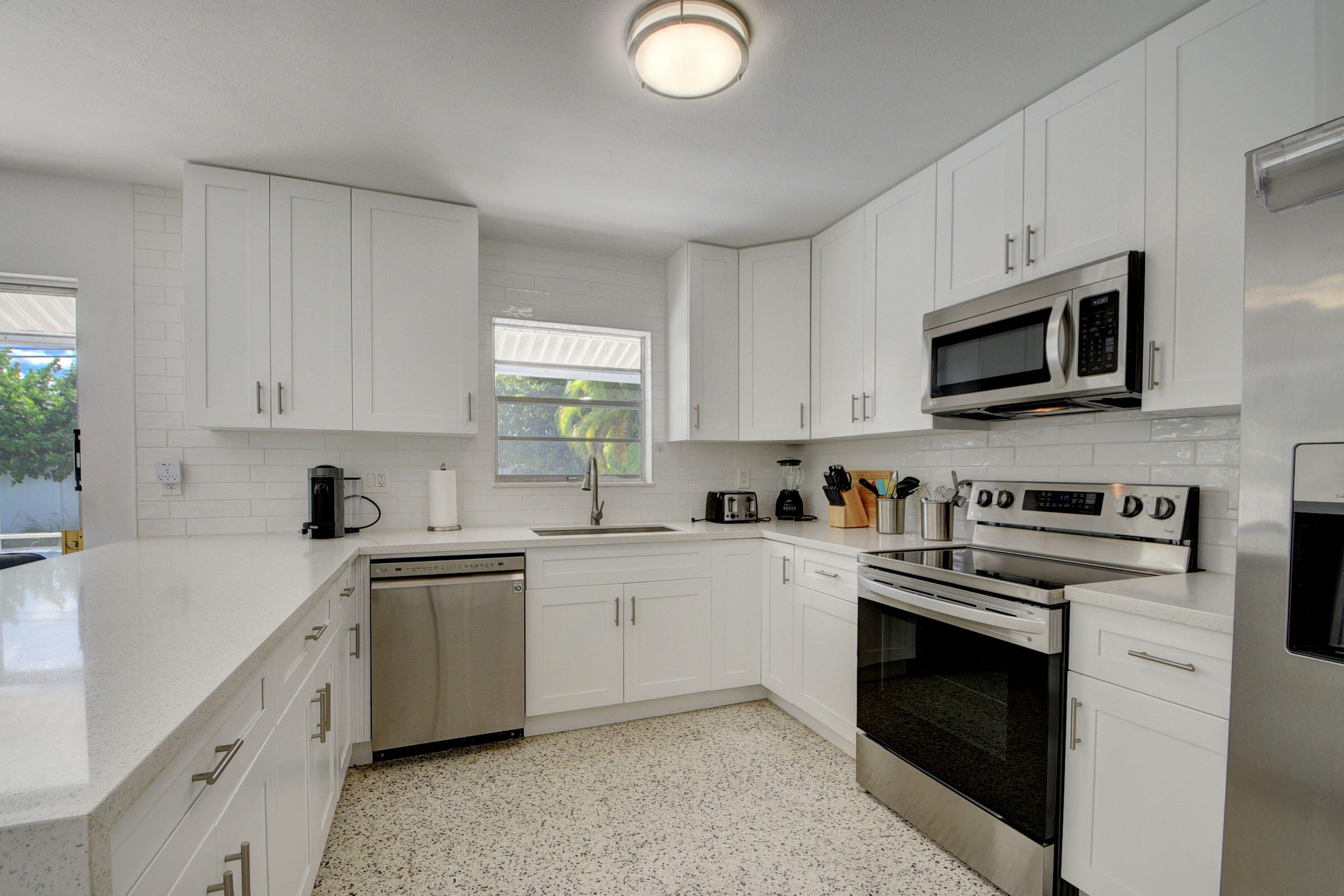 1171 Bimini Lane Singer Island, FL 33404 - Photo 21 of 61 a kitchen with cabinets stainless steel appliances a sink and a window