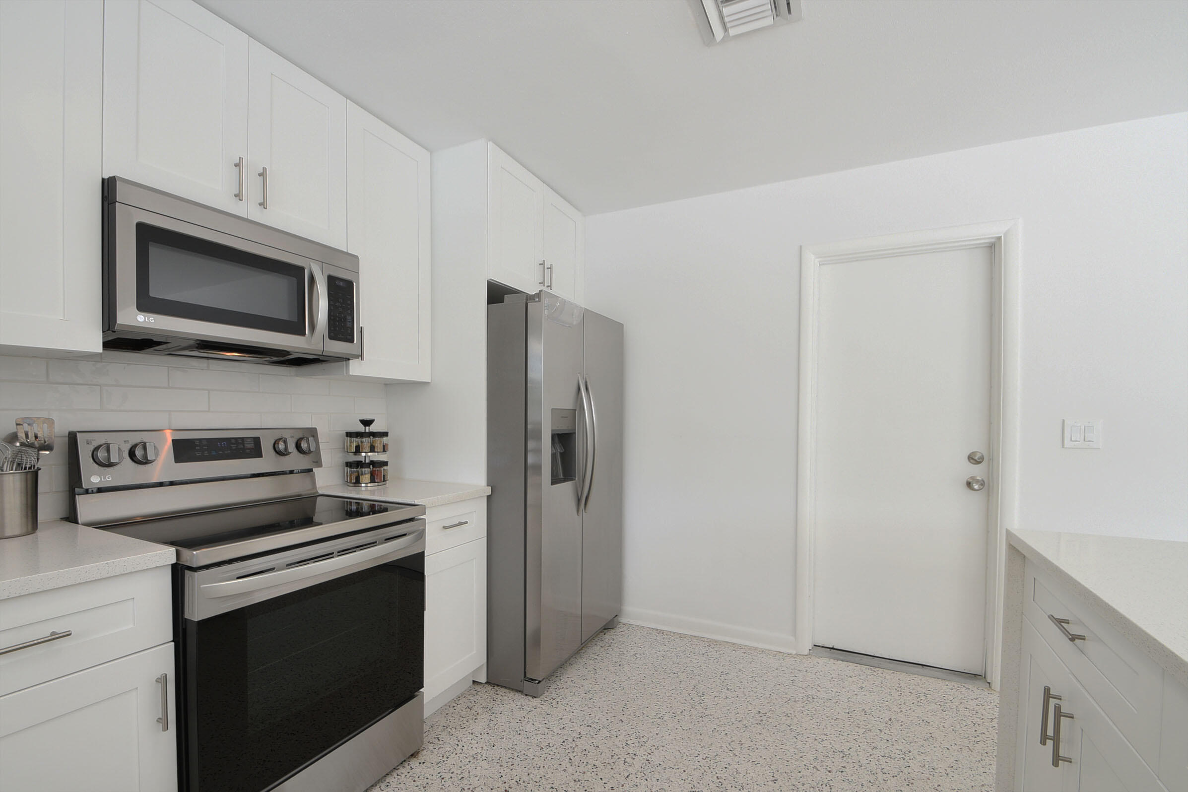 1171 Bimini Lane Singer Island, FL 33404 - Photo 43 of 61 a kitchen with stainless steel appliances a stove microwave and refrigerator
