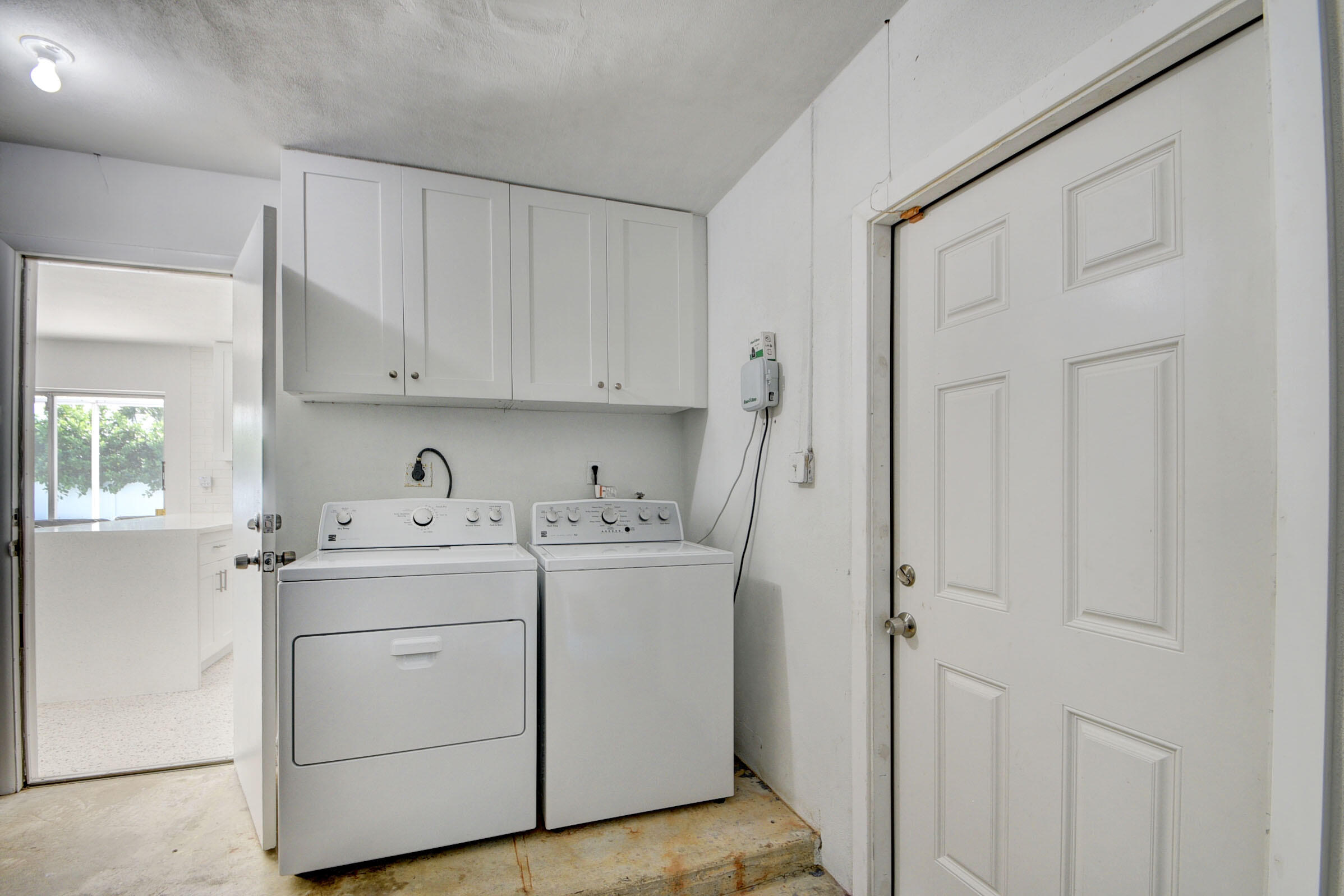 1171 Bimini Lane Singer Island, FL 33404 - Photo 44 of 61 a utility room with cabinets washer and dryer