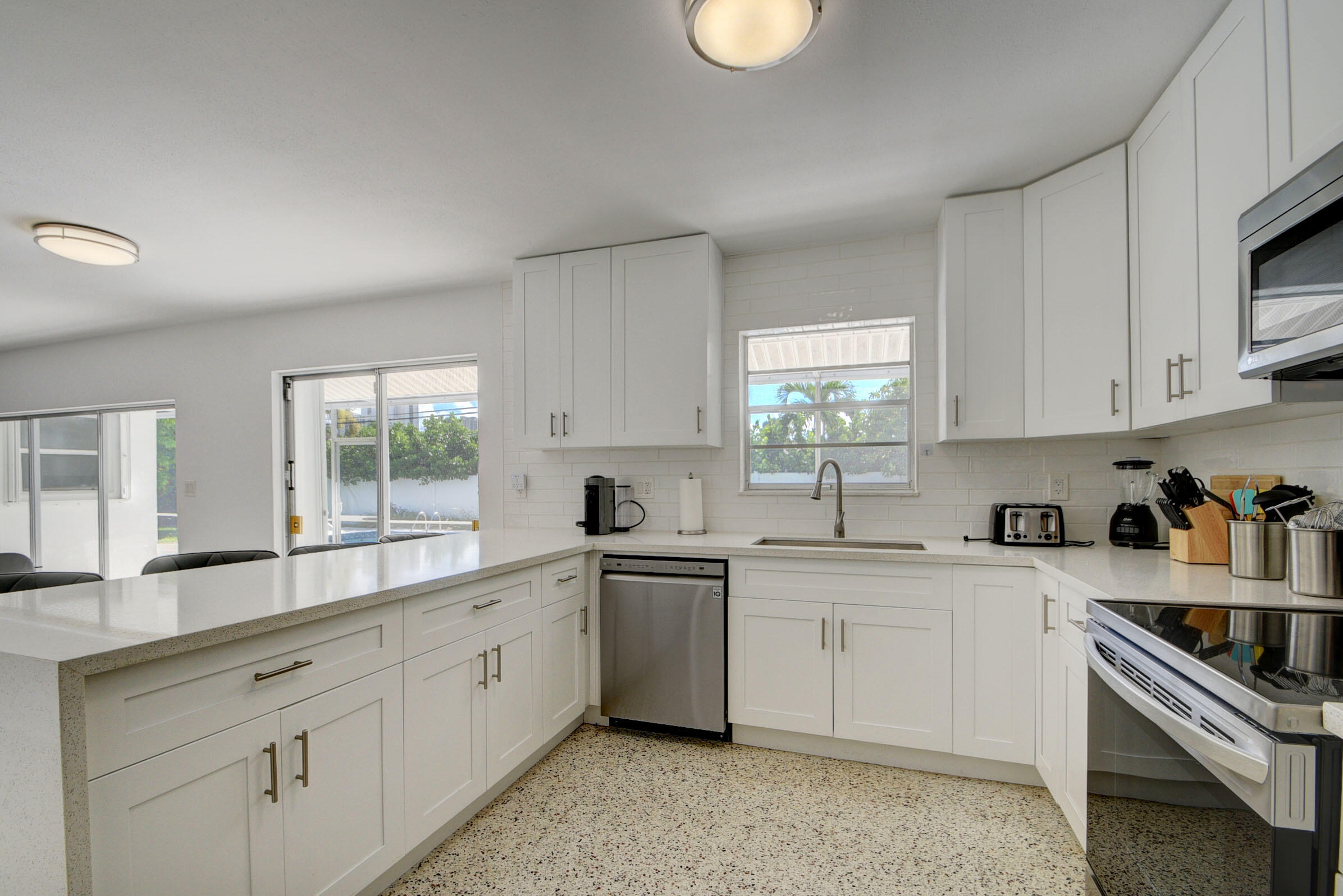 1171 Bimini Lane Singer Island, FL 33404 - Photo 9 of 61 a kitchen with white cabinets appliances a sink and a window