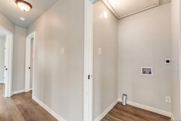 a view of an empty room with wooden floor and closet