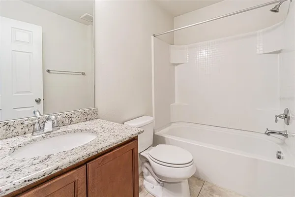 a bathroom with a granite countertop sink a toilet and shower