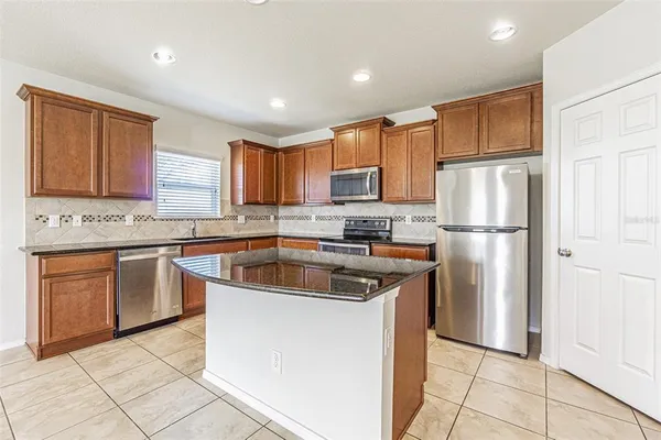 a kitchen with stainless steel appliances granite countertop a refrigerator sink and cabinets