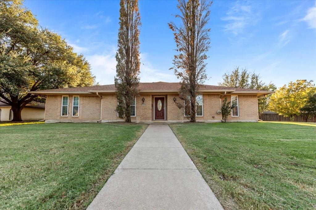 front view of a house with a yard and an trees