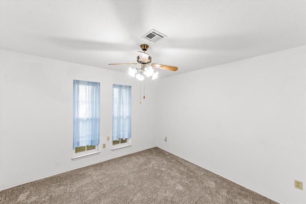 1812 Trinity Drive Waco, TX 76710 - Photo 13 of 24 an empty room with a chandelier fan and windows