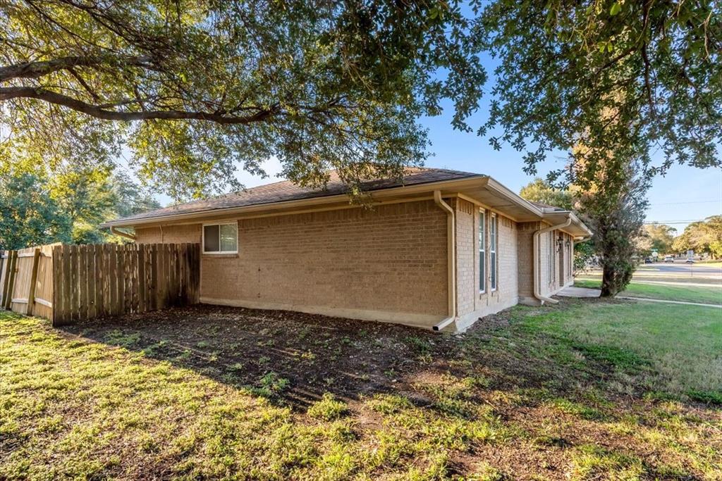 1812 Trinity Drive Waco, TX 76710 - Photo 18 of 24 a view of a house with a small yard plants and large tree
