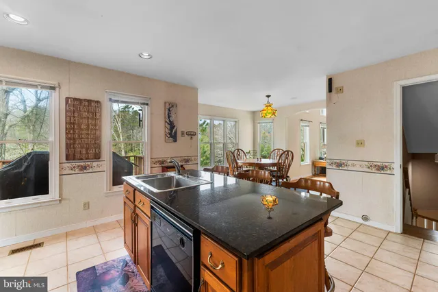 a kitchen with stainless steel appliances granite countertop a sink a stove and refrigerator