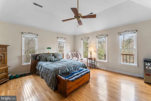 a spacious bedroom with a bed a couch and a flat screen tv