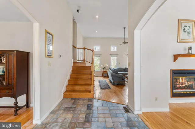 a view of a hallway with wooden floor and a living room