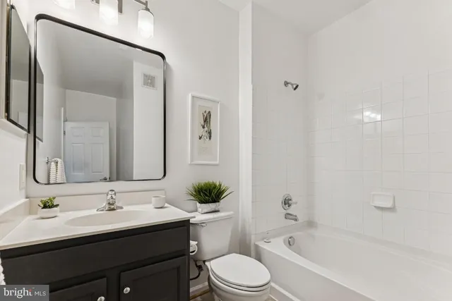 a bathroom with a bathtub shower sink mirror and toilet