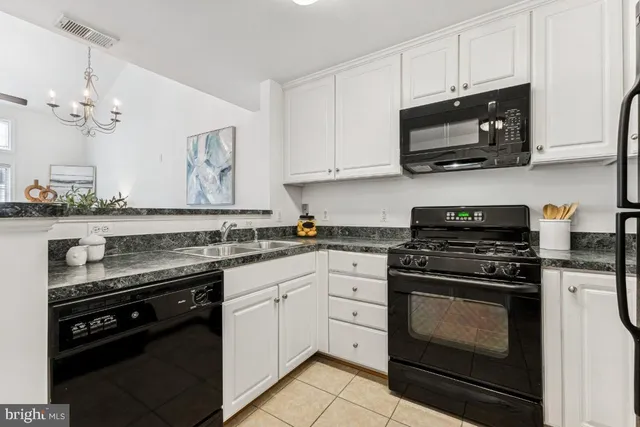 a kitchen with stainless steel appliances granite countertop grey cabinets a stove a sink and dishwasher