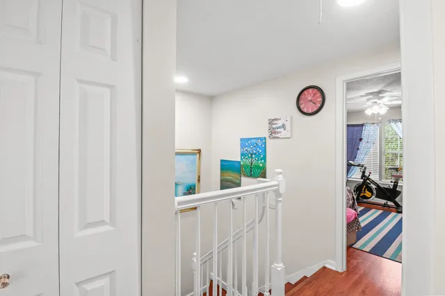 a view of a hallway with wooden floor and workspace