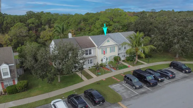 an aerial view of residential houses with outdoor space and trees