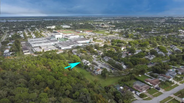 an aerial view of residential houses with outdoor space and trees