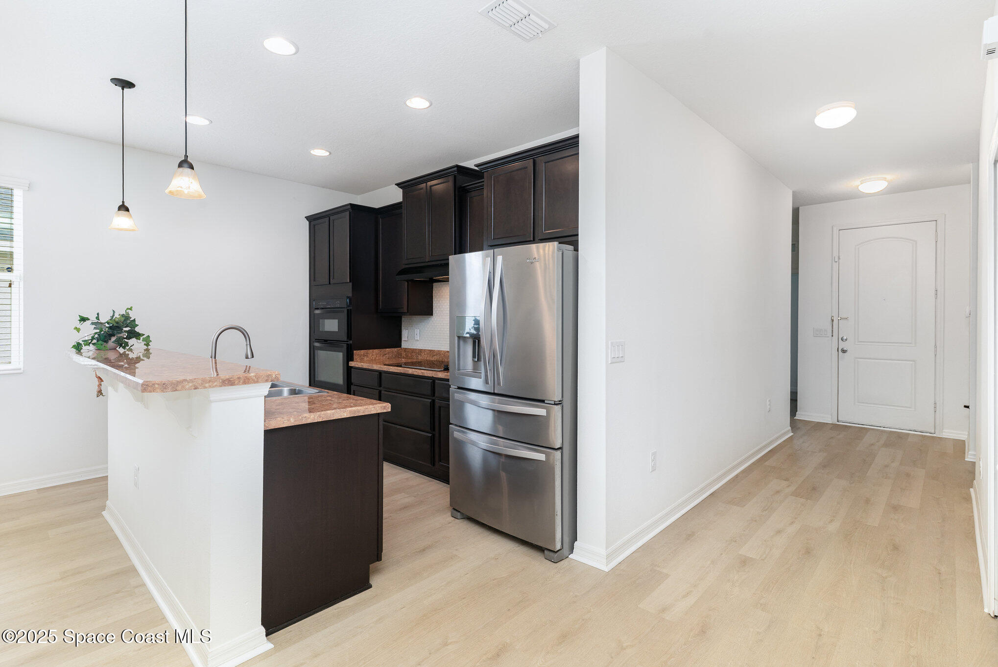 122 Port Royal Court Sebastian, FL 32958 - Photo 2 of 26 a kitchen with kitchen island a counter top space a refrigerator and a sink