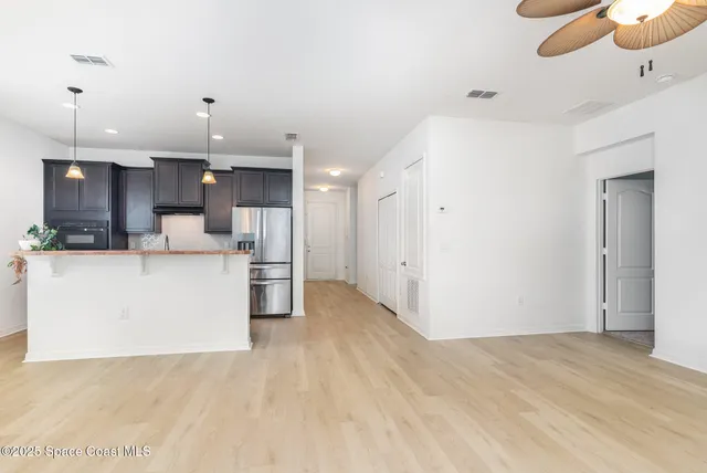 a view of kitchen with kitchen island a sink stainless steel appliances and cabinets
