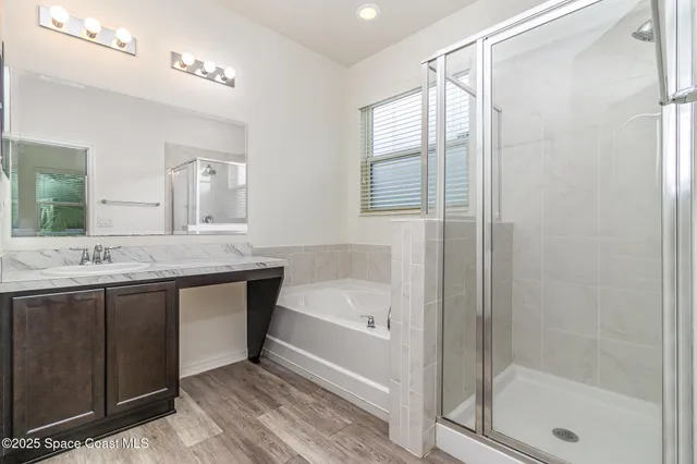 a bathroom with a granite countertop sink a mirror and a bathtub
