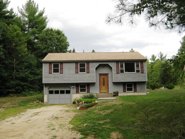 64 Colburn Road Milford, NH 03055 - Photo 1 of 17 a front view of a house with a garden