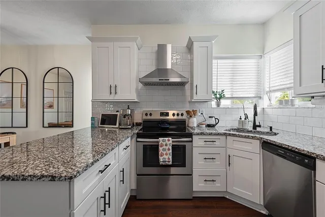 a kitchen with stainless steel appliances granite countertop a stove sink and cabinets