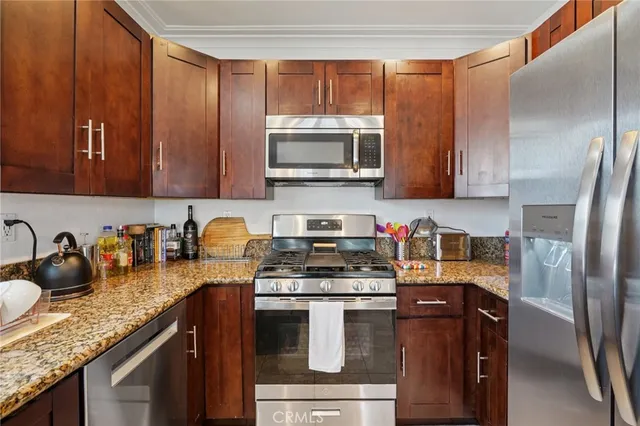 a kitchen with granite countertop a sink stove and microwave