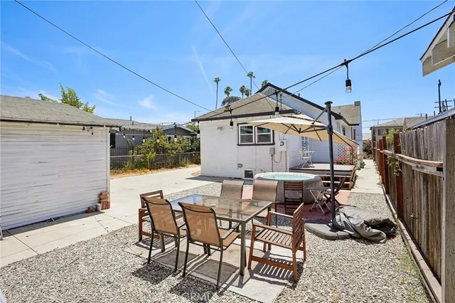 a patio with table and chairs and potted plants