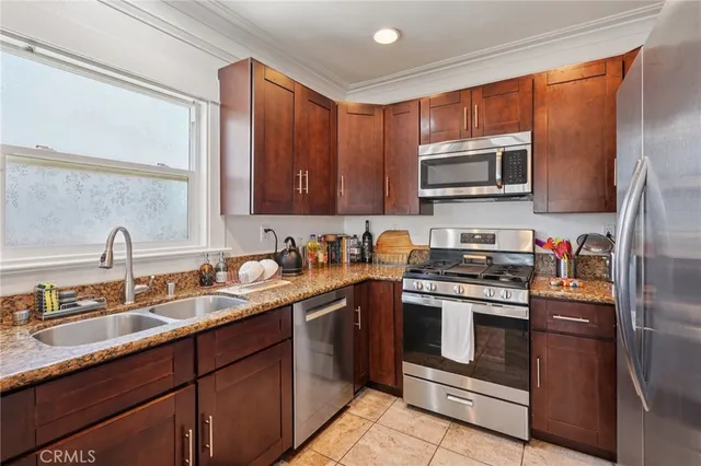 a kitchen with stainless steel appliances granite countertop a sink stove microwave and refrigerator