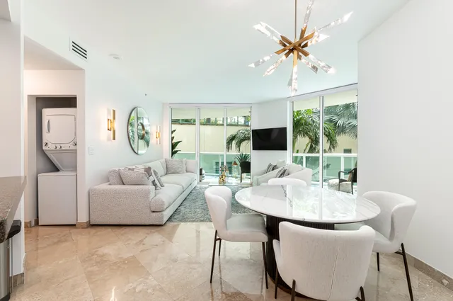 a living room with furniture a large window and a chandelier