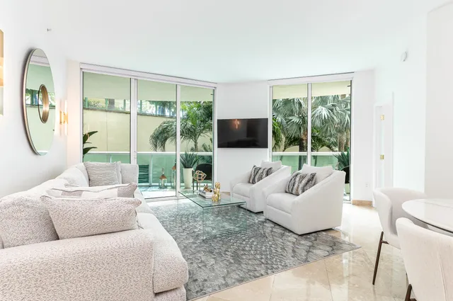 a living room with furniture a flat screen tv and a large window