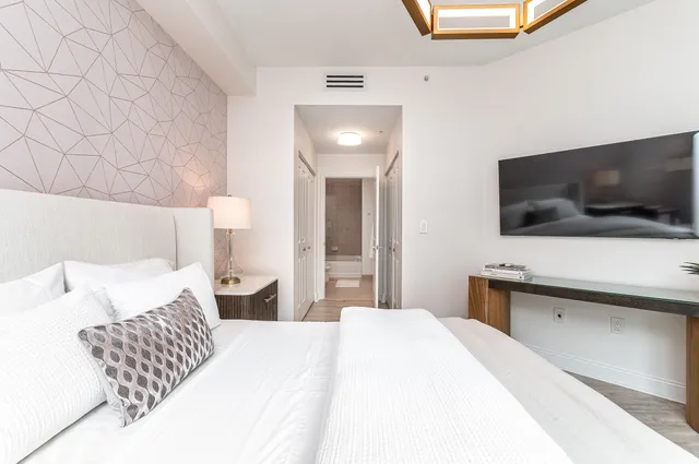 a bedroom with a bed and a flat screen tv