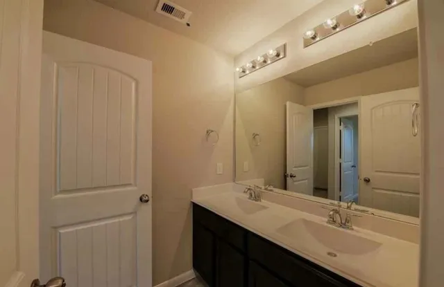 a bathroom with a double vanity sink and a mirror