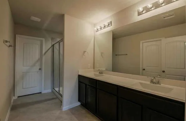 a bathroom with double sink and a mirror