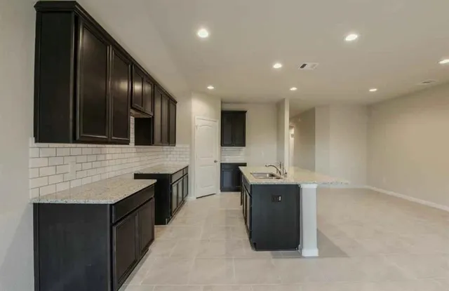 a kitchen with stainless steel appliances a sink stove and cabinets